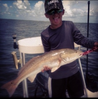 Child enjoys a massive redfish catch.